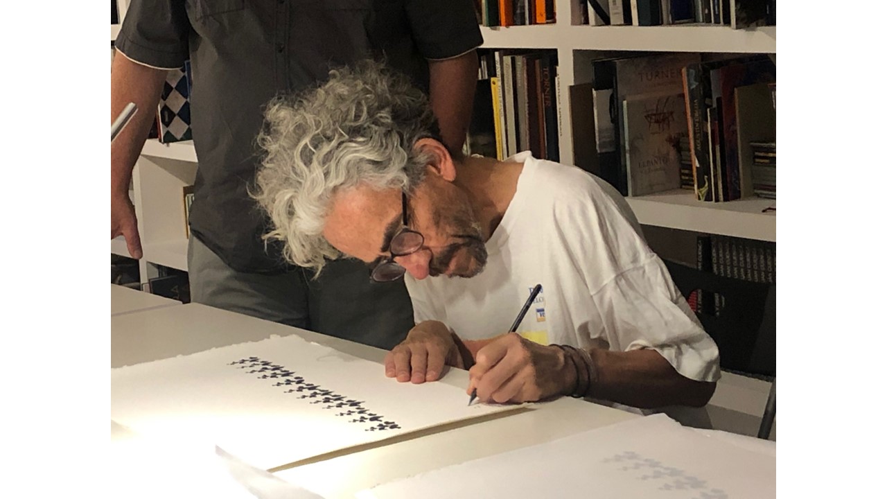 Antonio Caro firmando la serigrafía.